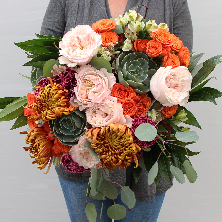 A Designer Collection bouquet features 30-35 stems of premium flowers including Garden roses, roses, succulents, Charmelia, greenery, and more.